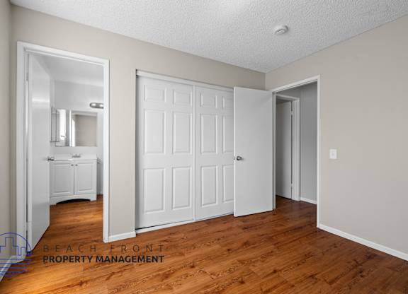 A room with a white door and a mirror on the wall.