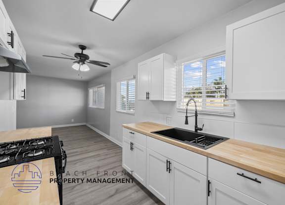 A kitchen with a stove top and a sink.