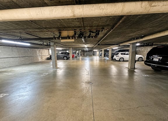 A parking garage with concrete floors and pillars.