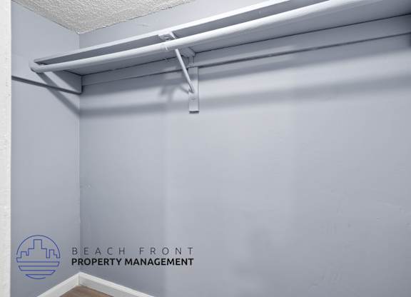 A white shelf with a white rod and a white hook on it.