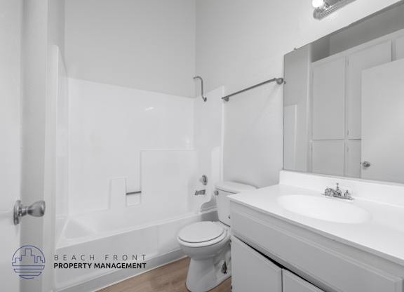 A white bathroom with a toilet, sink, and bathtub.
