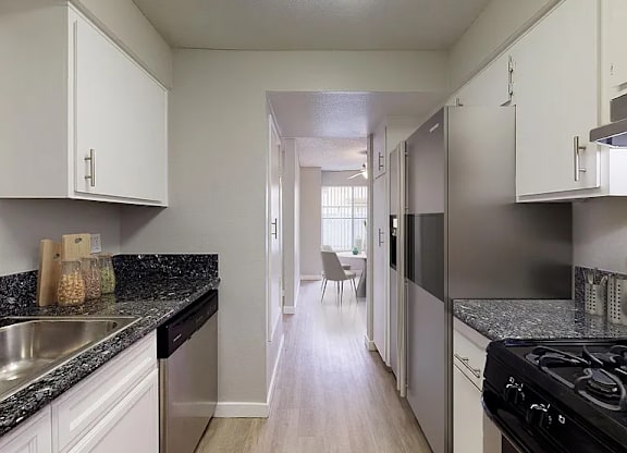 A kitchen with white cabinets and a black stove top oven.