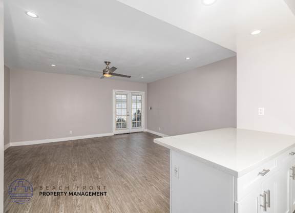 A spacious room with a ceiling fan and a white countertop.