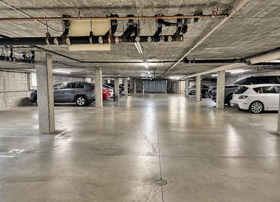 A parking garage with concrete floors and pillars.