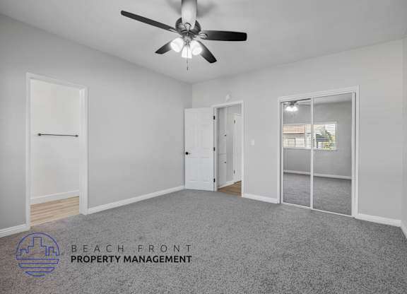A spacious room with a ceiling fan and a logo for Beach Front Property Management.