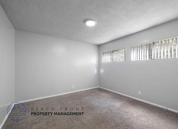 the living room of a house with white walls and carpet