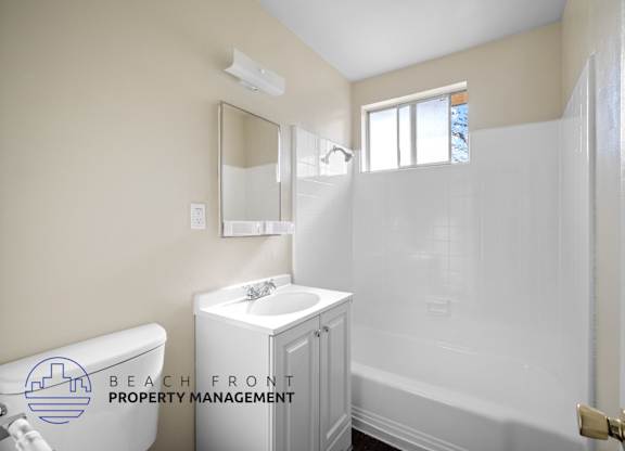 a white bathroom with a white sink and shower and a white tub