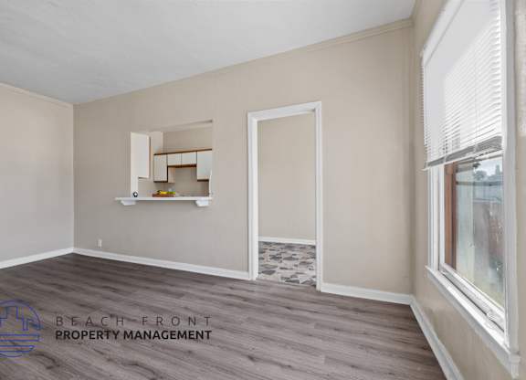 A room with a window and a shelf with a logo of Beach Front Property Management.