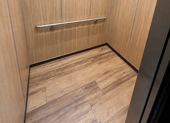 A wooden hallway with a black wall on the right side.