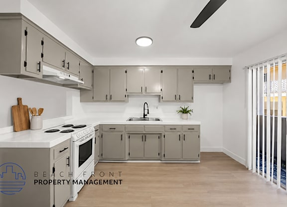 A modern kitchen with a stove top oven and a sink.