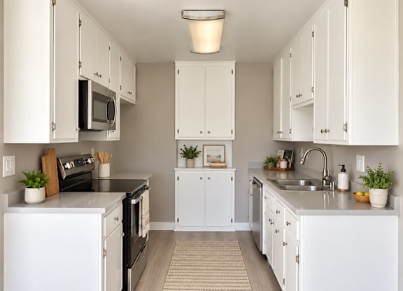 A kitchen with white cabinets and appliances.