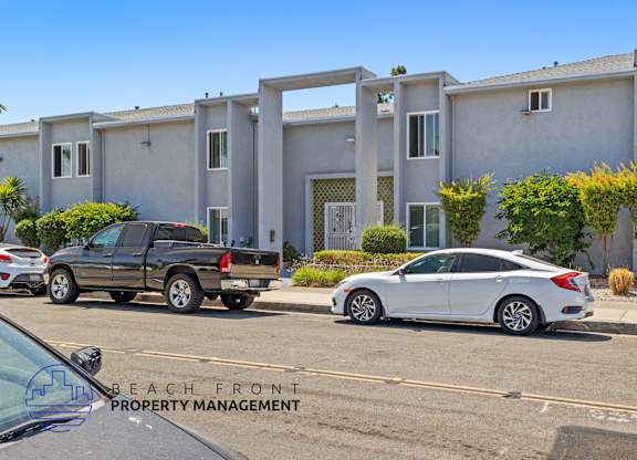A white car is parked in front of a building with the words