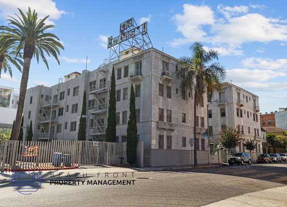 a building on the corner of a street with palm trees