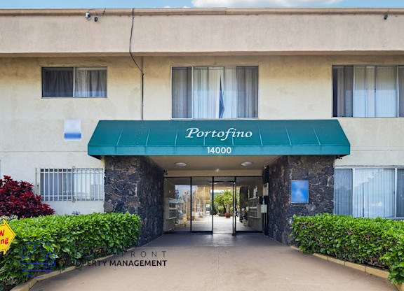The entrance to a building with a green awning that says Porrofino.