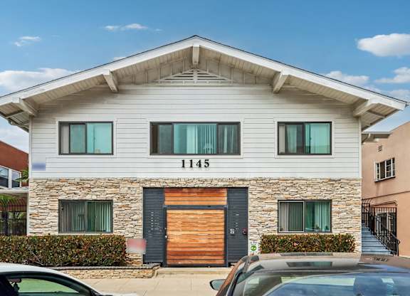 A modern house with a stone facade and a wooden door.