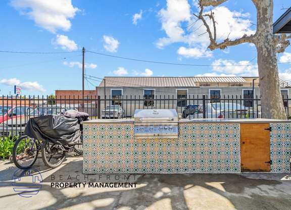 a barbecue grill with a bike parked in front of a building