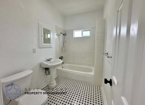 A white bathroom with a black and white checkered floor.