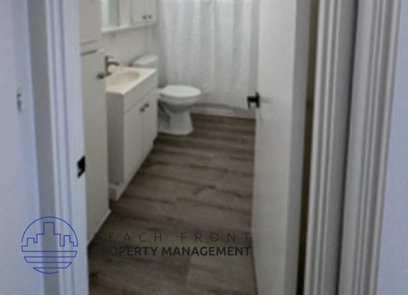 A bathroom with a toilet, sink, and bathtub.