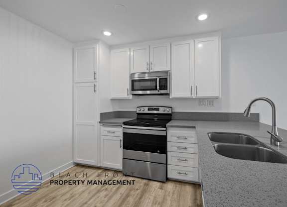 A modern kitchen with a stove, oven, microwave, and sink.