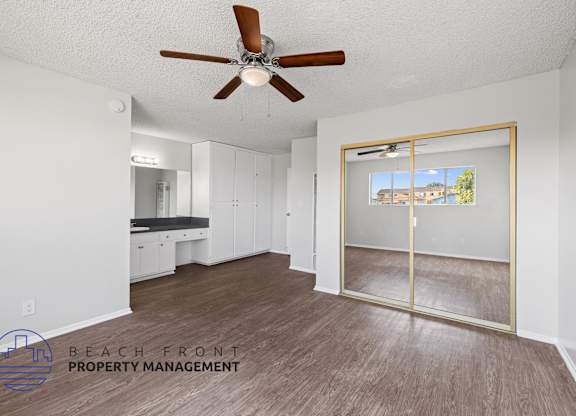 a living room with a ceiling fan and a mirror