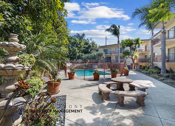 A patio area with a pool and a fountain.