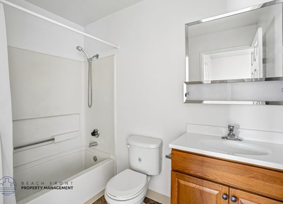 A white bathroom with a toilet, sink, and shower.
