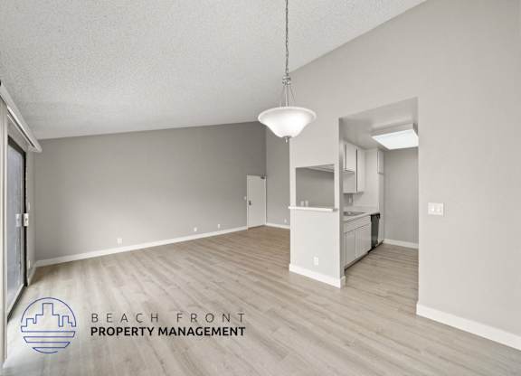 the spacious living room and kitchen of this renovated beachfront property