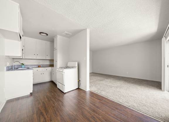 A white kitchen with a white fridge and a white baby crib.