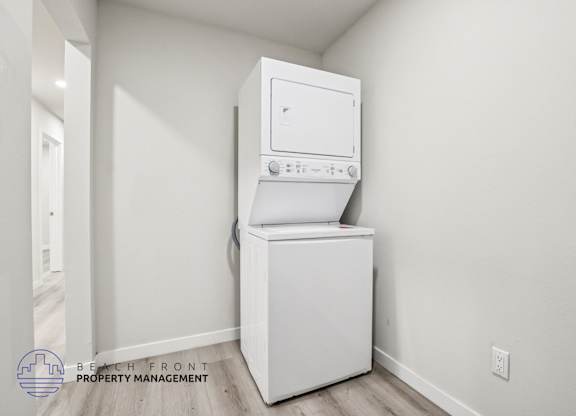 A white washing machine and dryer in a room with white walls.
