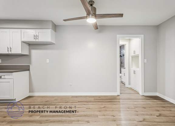 A room with a ceiling fan and wooden flooring.