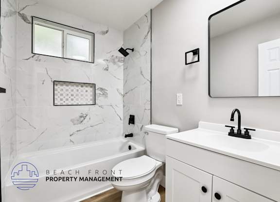 A bathroom with a marble wall and a white sink.
