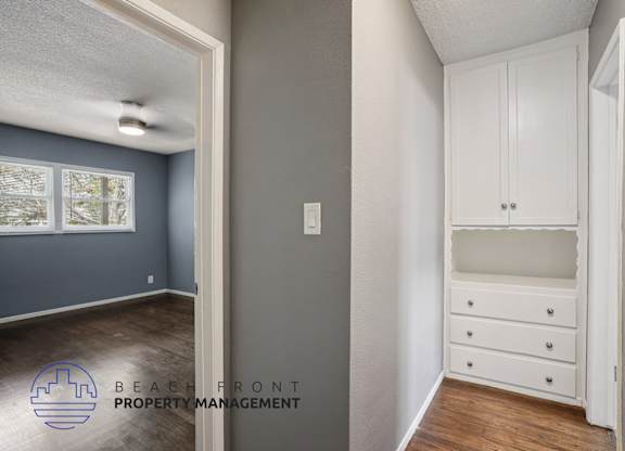 A room with a white cabinet and a window.