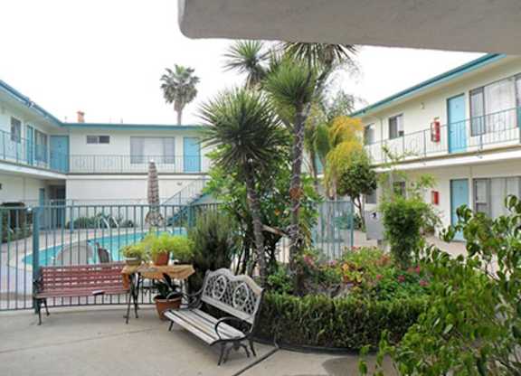 A patio with a table and chairs overlooks a pool.