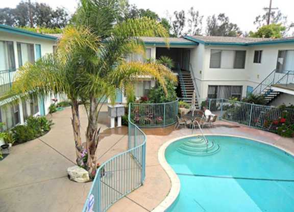 A pool in a courtyard surrounded by a fence.