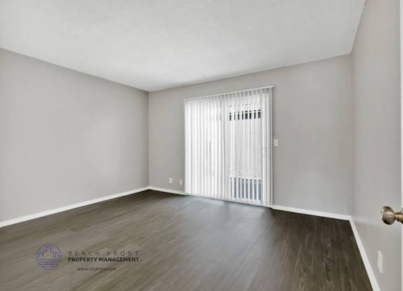 A room with a wooden floor and a white door.