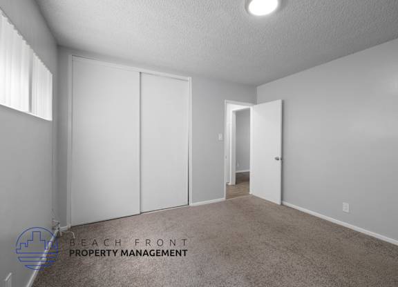 a master bedroom with white closets and a carpeted floor