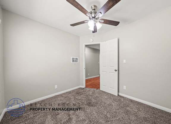 A room with a ceiling fan and a carpeted floor.