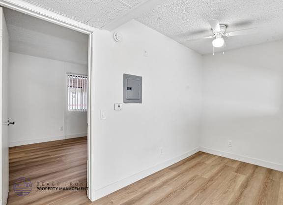 A room with a white wall and a wooden floor.
