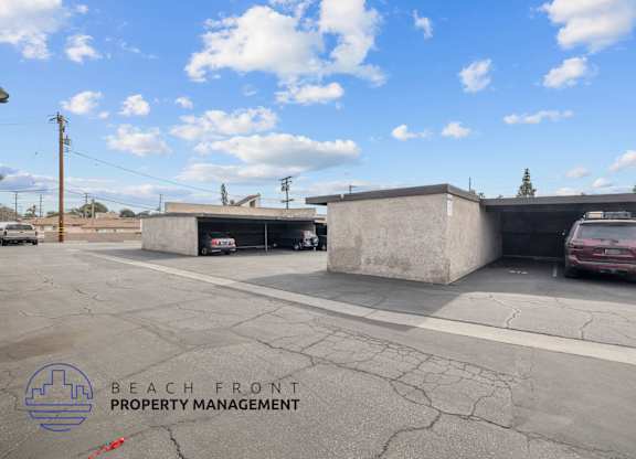 A parking lot with a car parked in a garage and a logo for Beach Front Property Management.