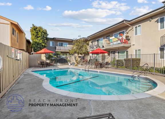 A pool surrounded by a fence and a bench with the words Beach Front Property Management.