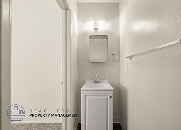 A small white bathroom with a sink and mirror.
