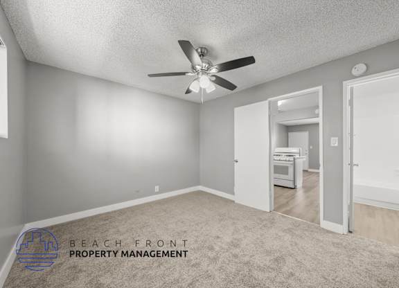 A room with a ceiling fan and a carpeted floor.