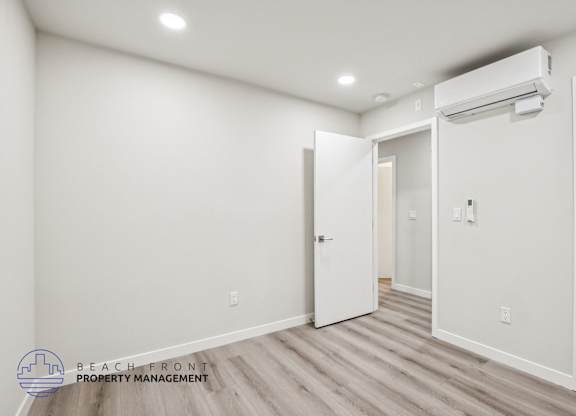 A room with a white door and a window with blinds.