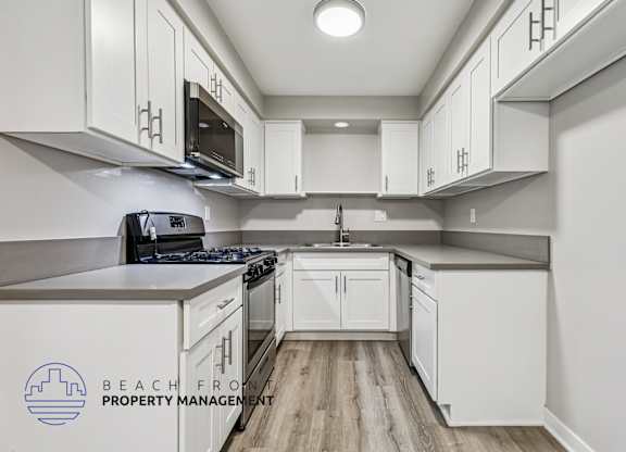 A kitchen with white cabinets and a stove top oven.