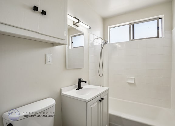 A white bathroom with a toilet, sink, and bathtub.