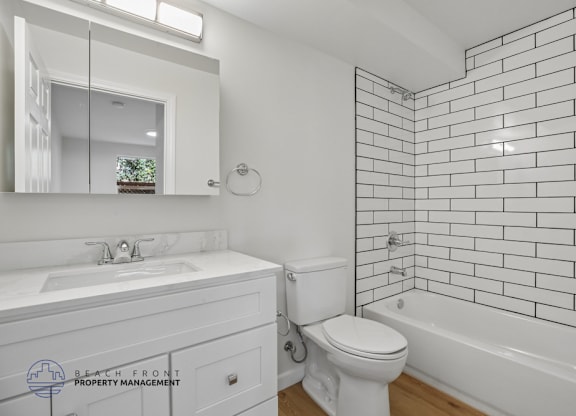 A white bathroom with a sink, toilet, and bathtub.