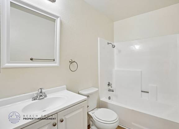 A white bathroom with a sink, toilet, and bathtub.