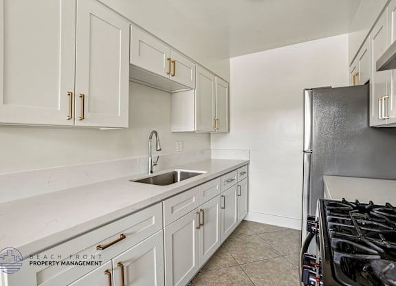 A kitchen with white cabinets and a black stove.