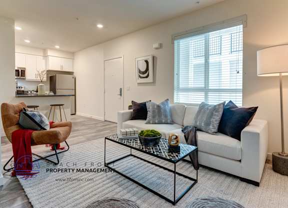 A modern living room with a glass coffee table and a white sofa.