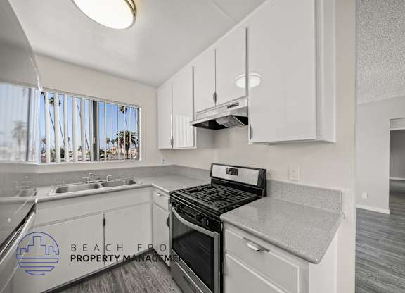 A kitchen with a stove top oven and a sink.